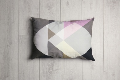 Photo of Soft decorative pillow on wooden background, top view