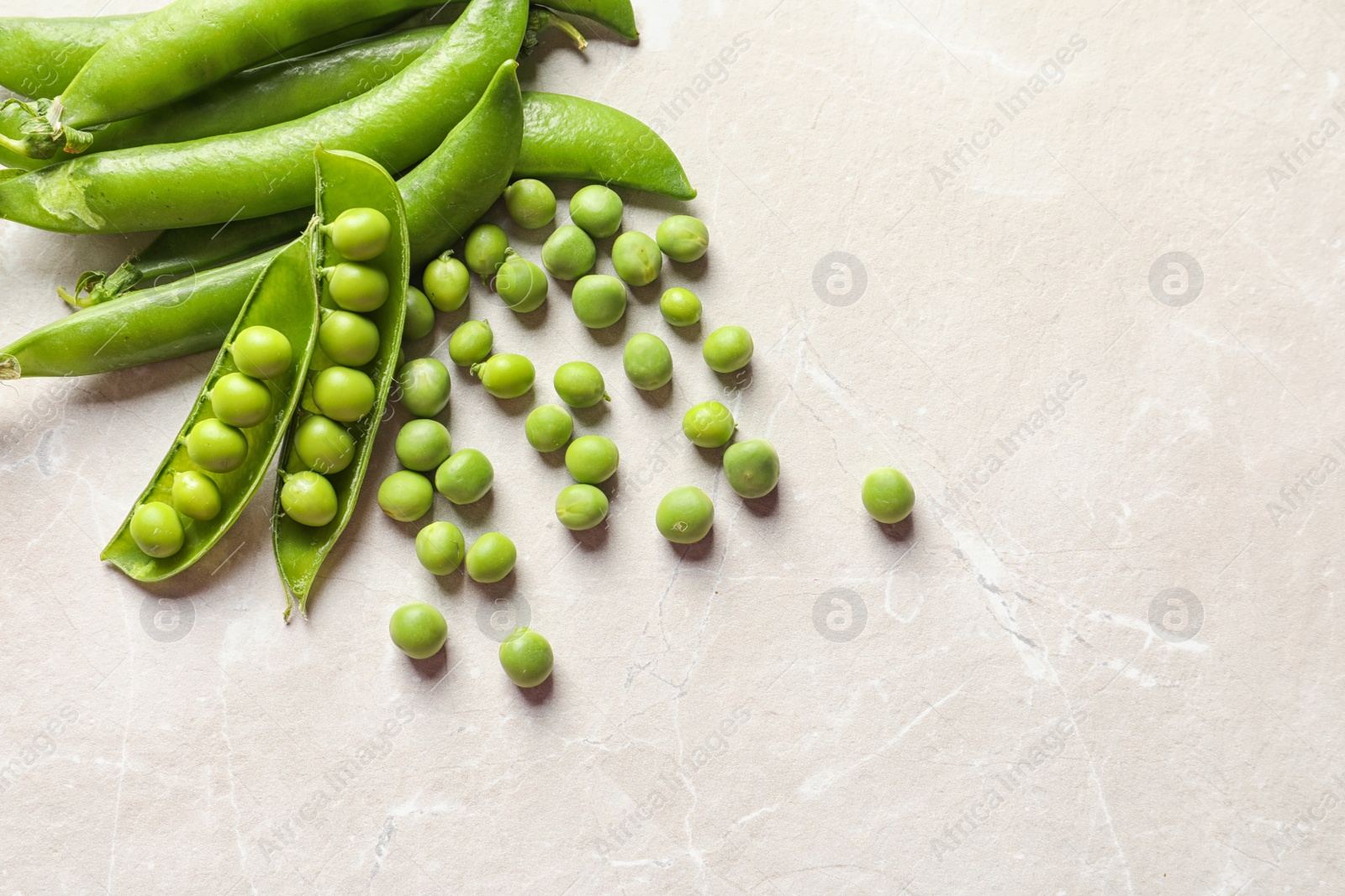 Photo of Fresh green peas on light background, top view