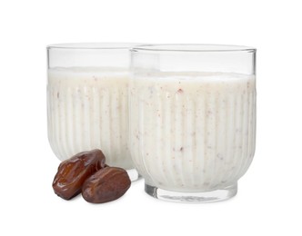 Photo of Glasses with delicious smoothie and dried dates on white background
