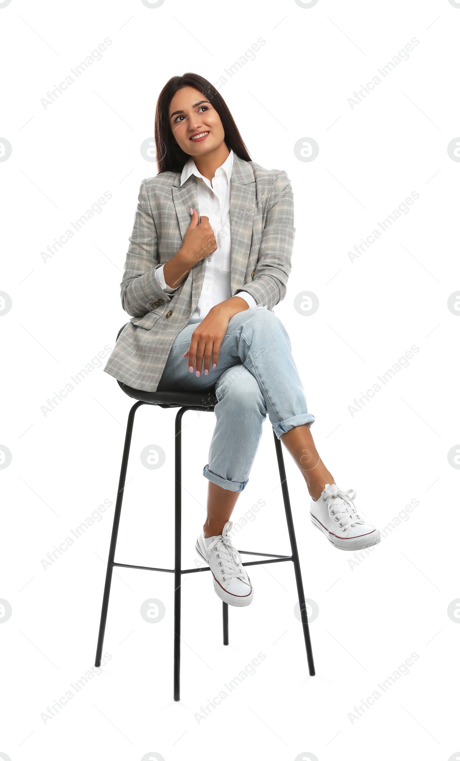 Photo of Beautiful young woman sitting on stool against white background