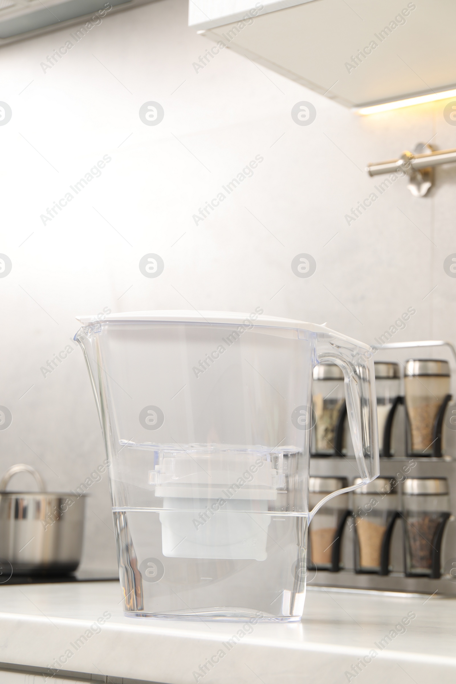 Photo of Water filter jug on white countertop in kitchen