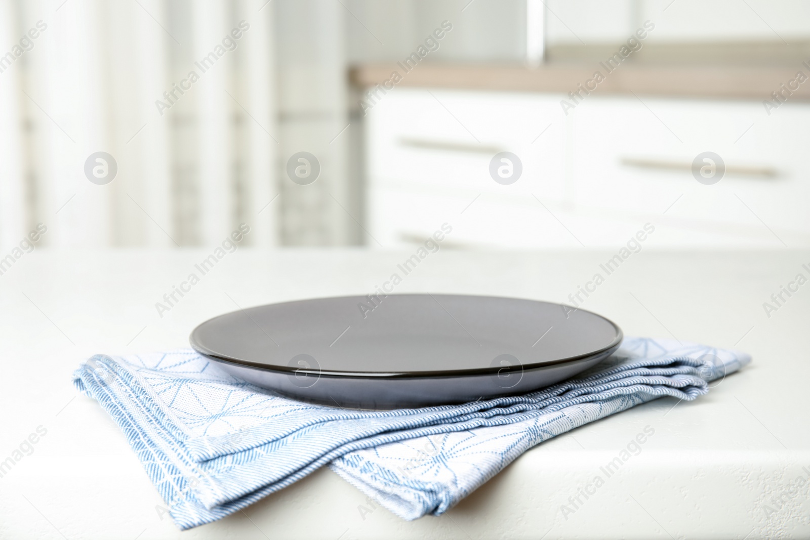 Photo of Empty plate and napkin on white table indoors