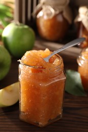 Photo of Delicious apple jam and fresh fruits on wooden table, closeup. Space for text