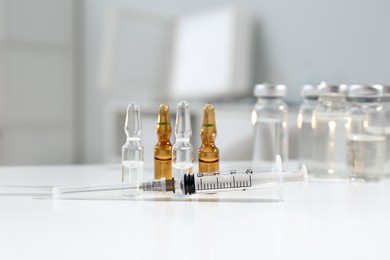 Syringe with ampules of medicines on white table