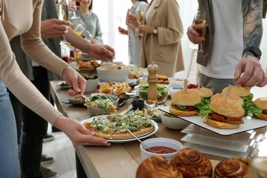 Photo of People near buffet table with food indoors, closeup. Brunch setting