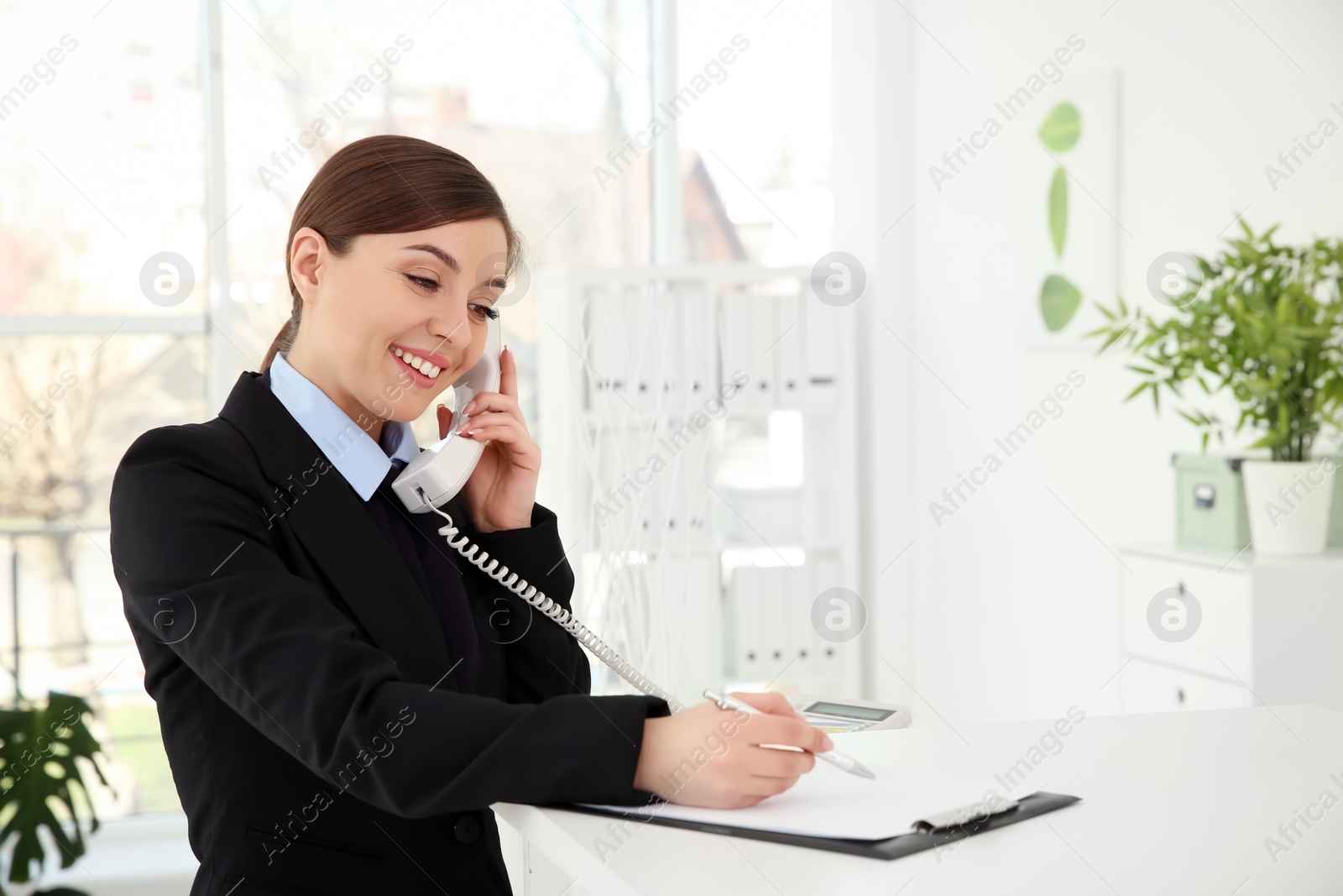 Photo of Busy female receptionist at workplace in hotel