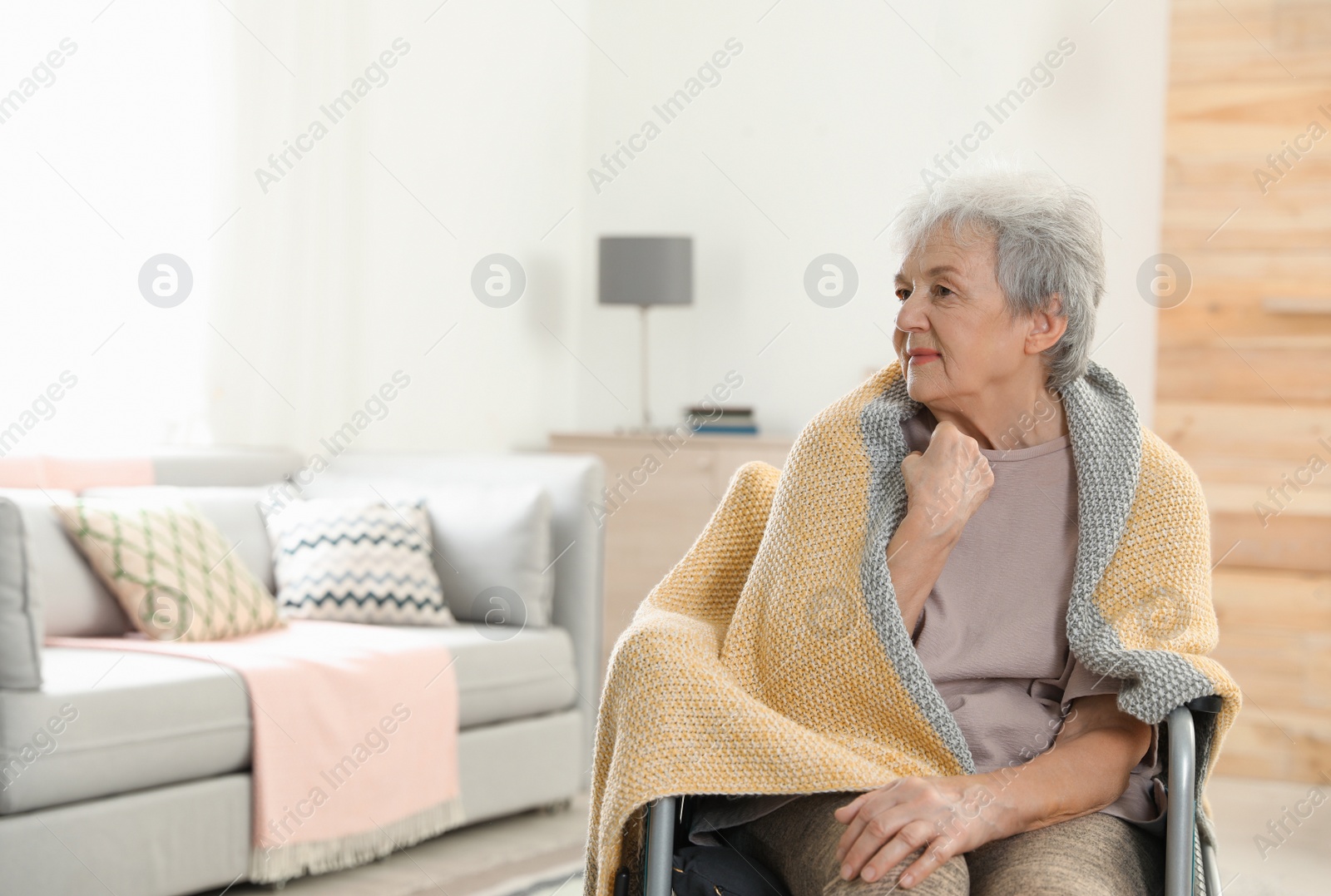 Photo of Handicapped elderly woman covered with blanket at nursing home, space for text. Assisting senior people