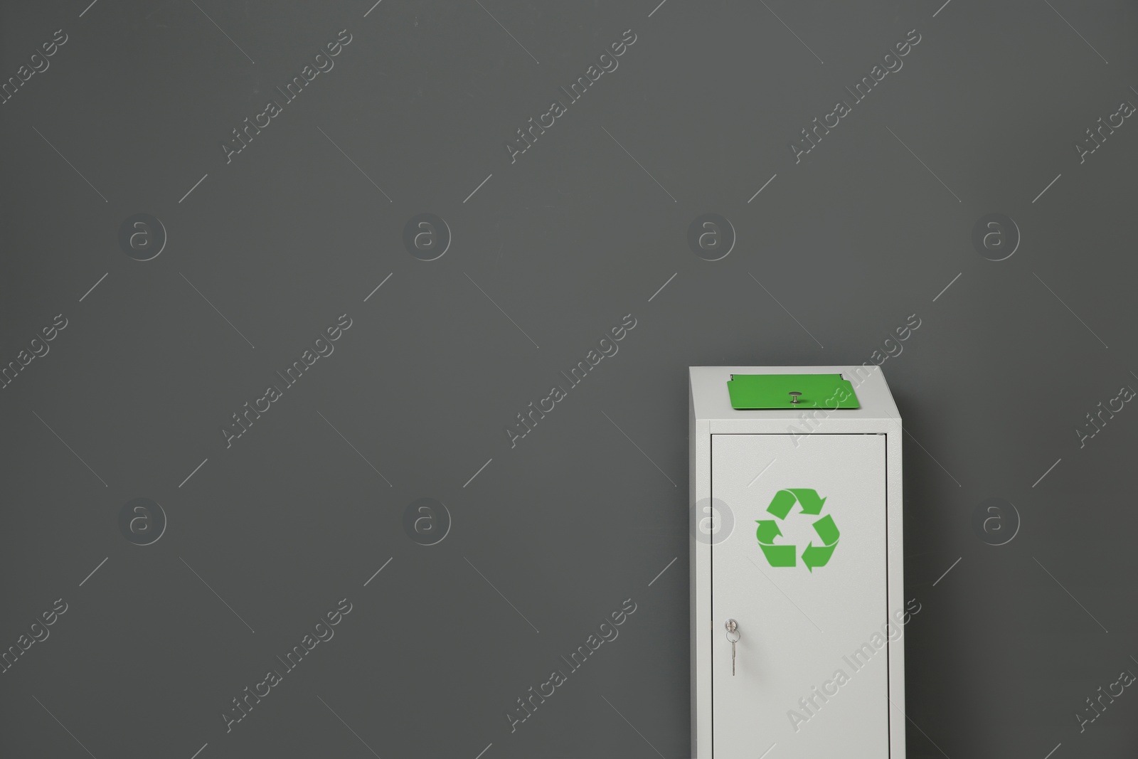 Photo of Metal bin on grey background, space for text. Waste recycling