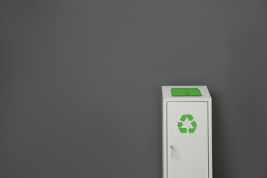 Metal bin on grey background, space for text. Waste recycling