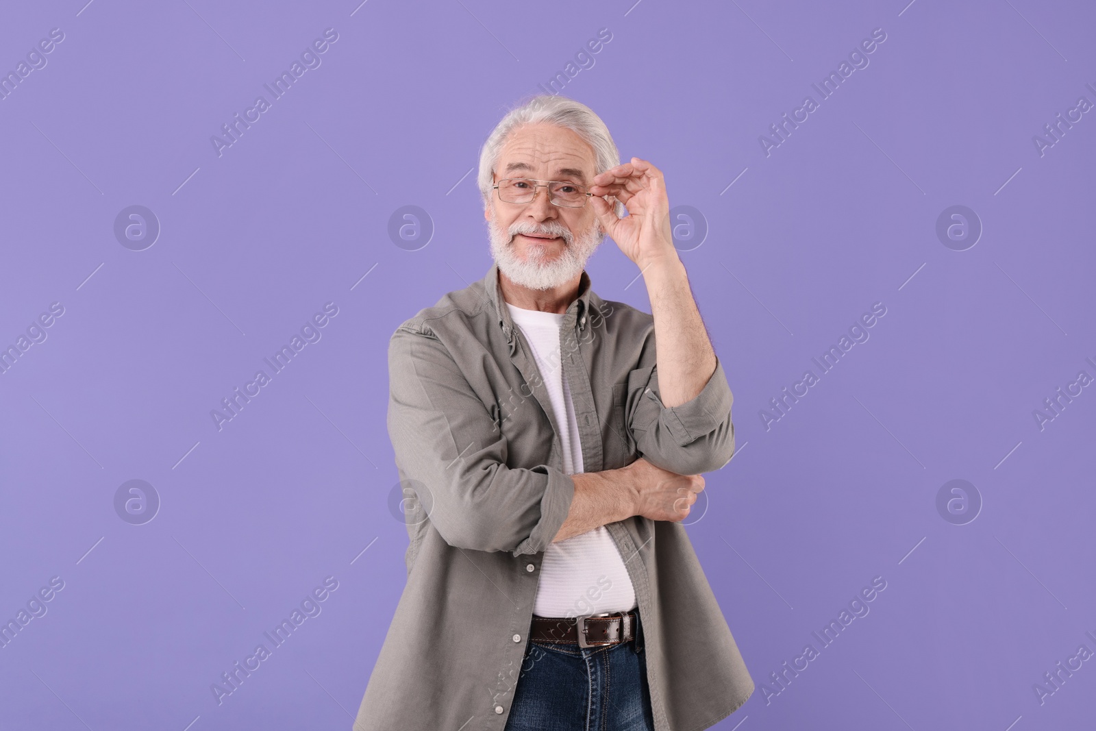 Photo of Portrait of stylish grandpa with glasses on purple background