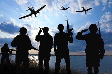 Image of Silhouettes of soldiers in uniform with assault rifles and military airplanes patrolling outdoors