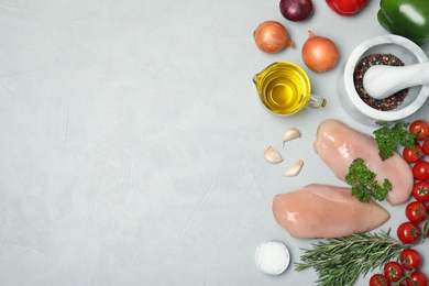 Photo of Flat lay composition with raw chicken breasts, products and space for text on gray background. Fresh meat