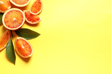 Fresh bloody oranges on color background, flat lay with space for text. Citrus fruits