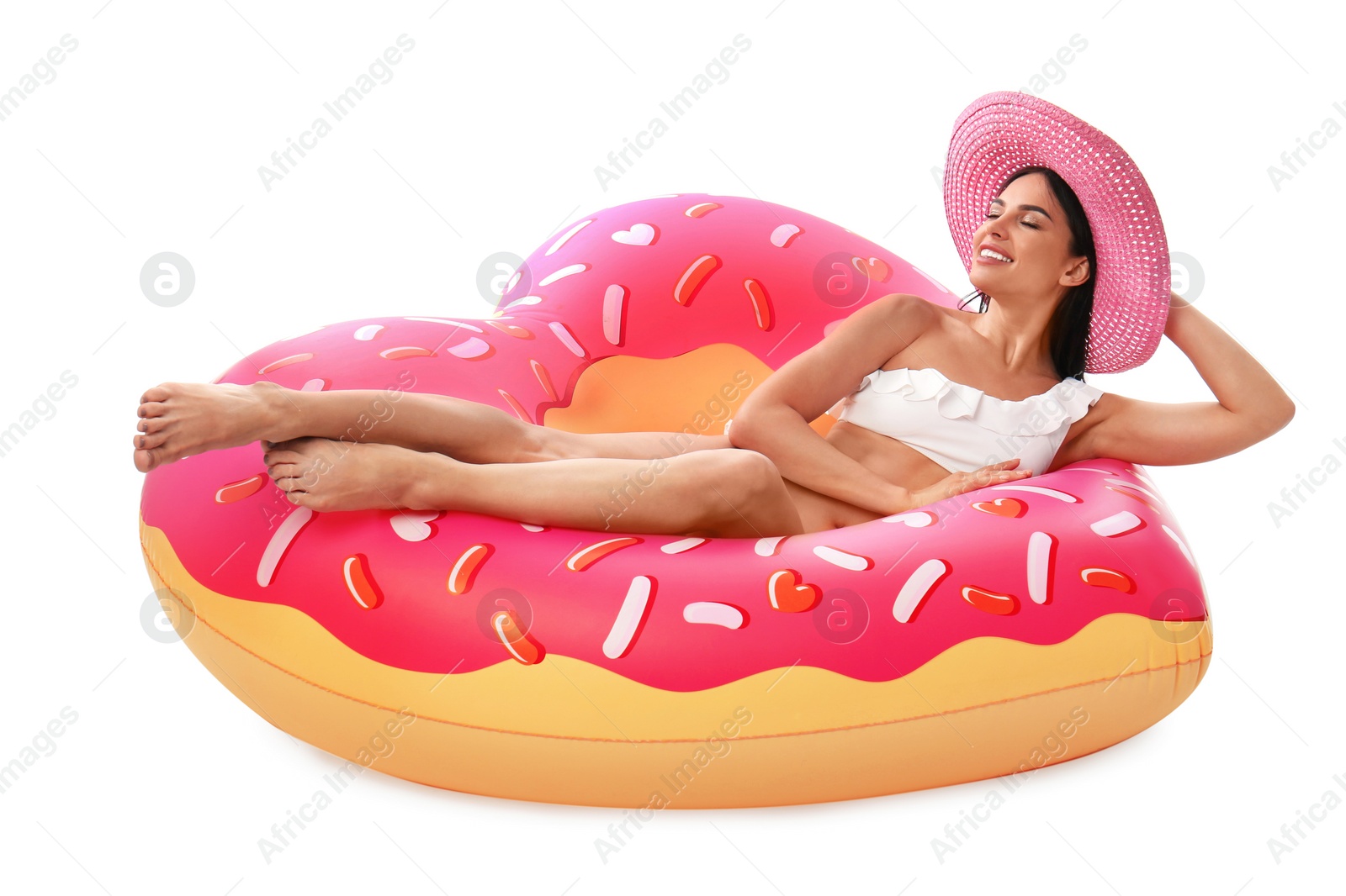 Photo of Beautiful young woman in stylish bikini with hat and inflatable ring on white background