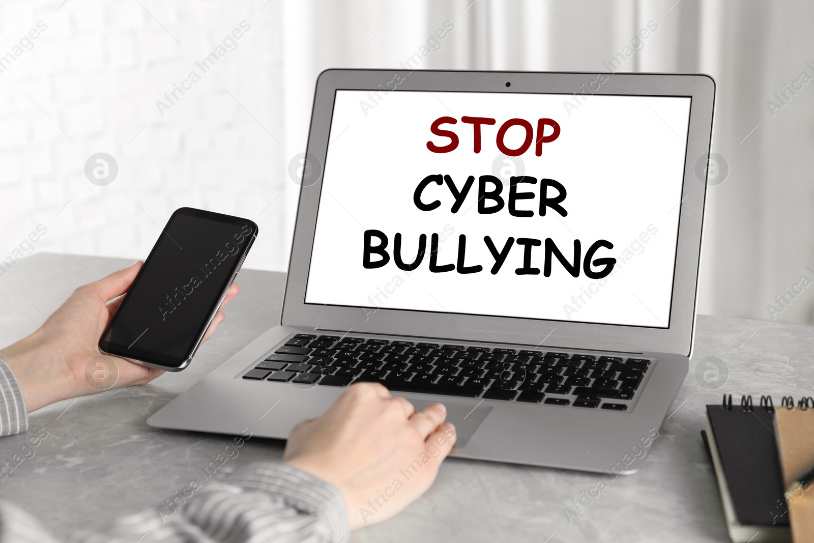 Image of Young woman using laptop at grey marble table, closeup. Cyber bullying