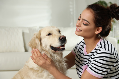 Young woman and her Golden Retriever at home. Adorable pet