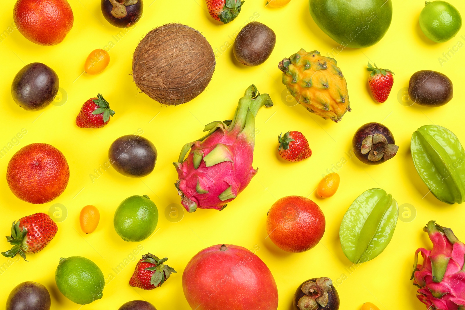 Photo of Assortment of fresh exotic fruits on yellow background, flat lay