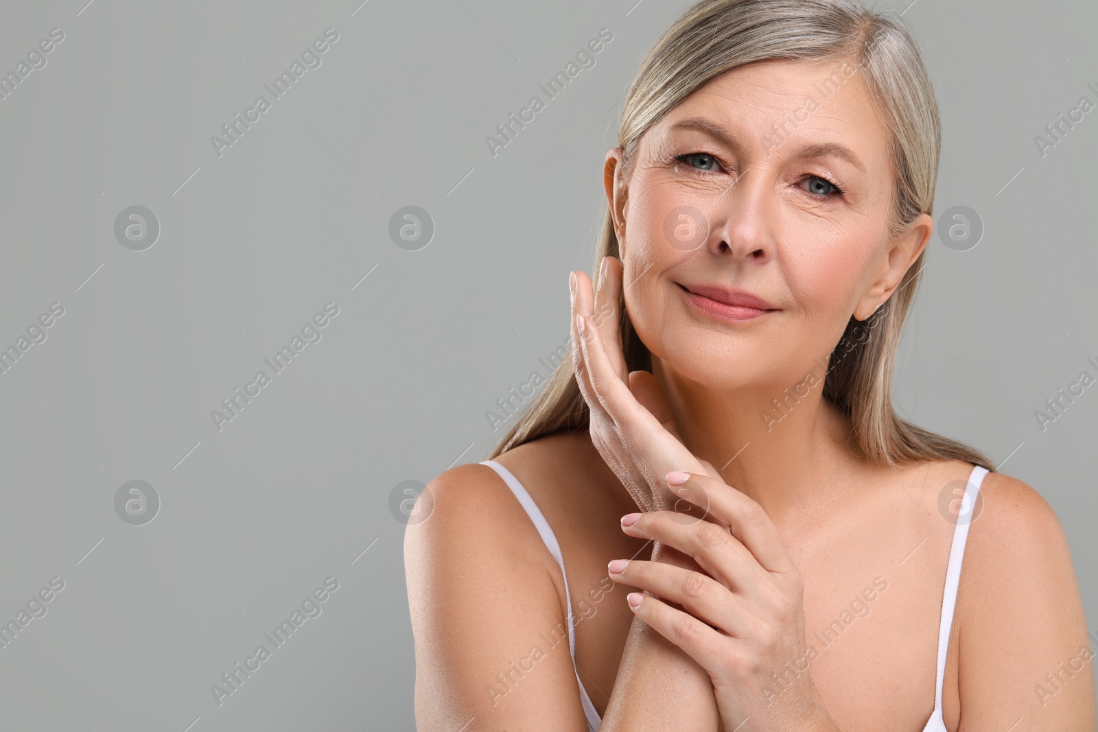 Photo of Beautiful mature woman with healthy skin on gray background, space for text