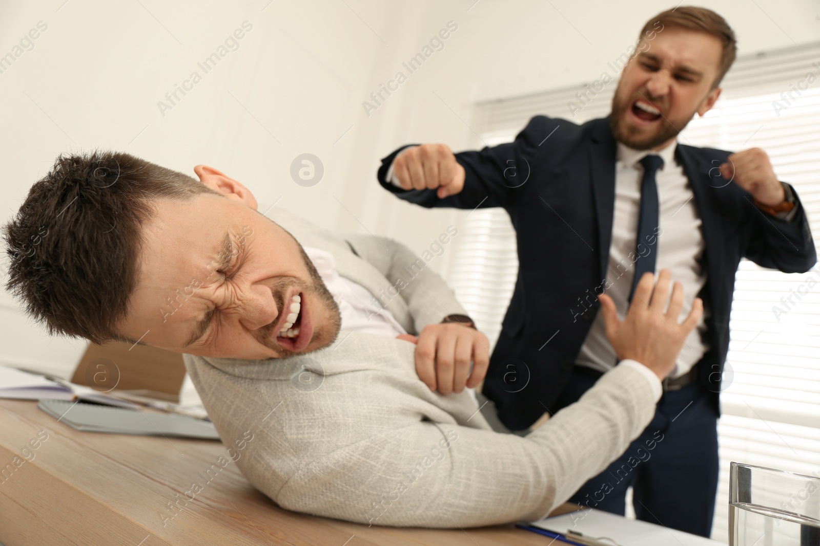 Photo of Emotional colleagues fighting in office. Workplace conflict