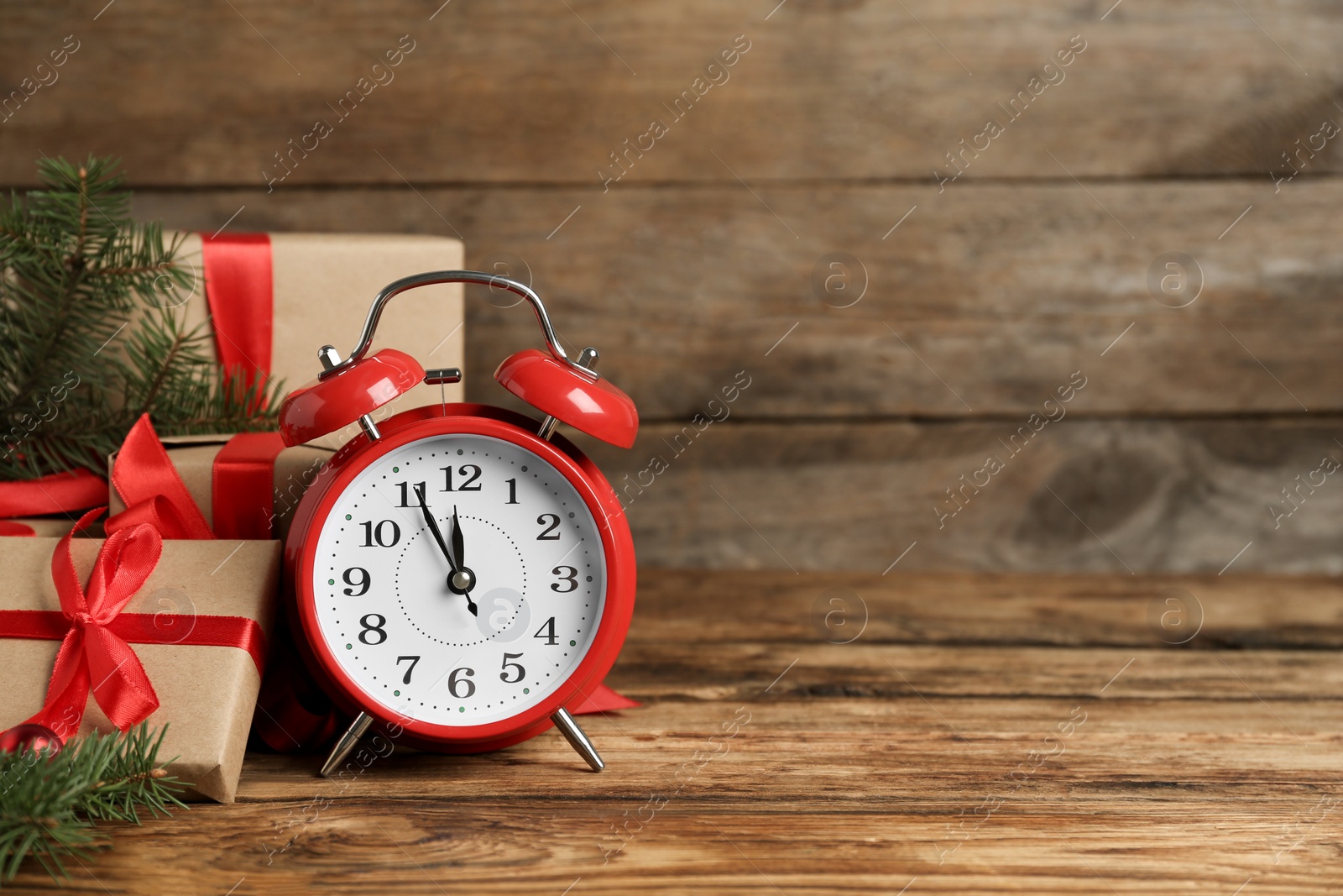 Photo of Christmas gifts and alarm clock on wooden table, space for text. Boxing day