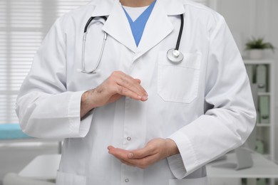 Photo of Young doctor holding something in modern clinic, closeup