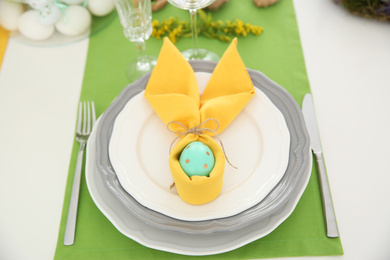 Photo of Festive Easter table setting with colorful egg, above view