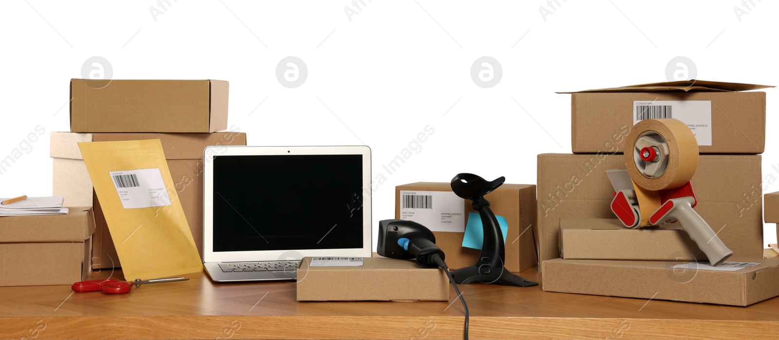 Photo of Parcels, laptop and barcode scanner on wooden table against white background. Online store