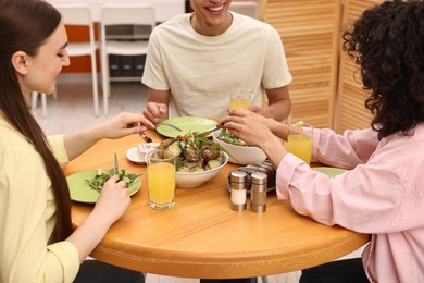 Photo of Friends having vegetarian meal at table in cafe