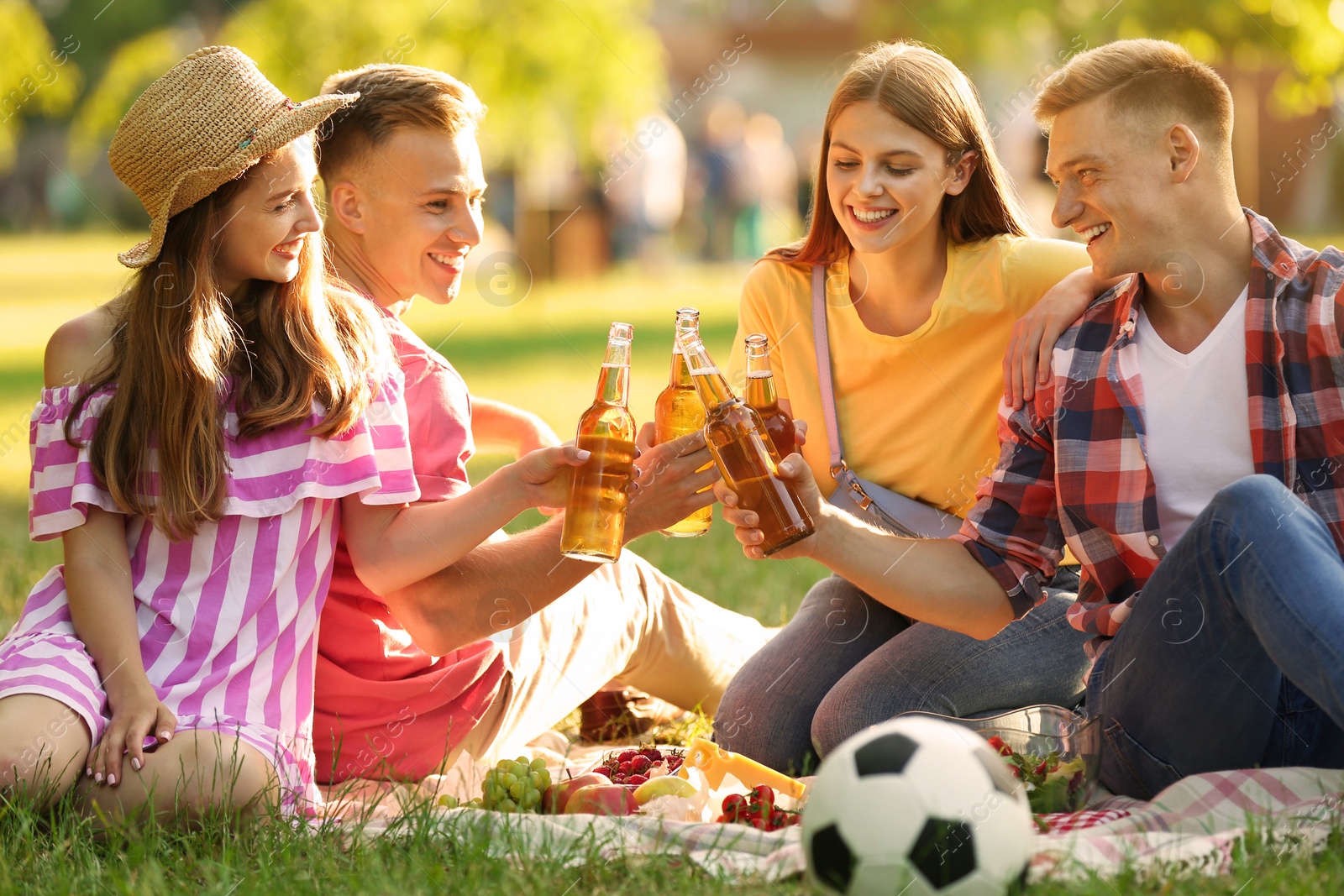 Photo of Young people enjoying picnic in park on summer day