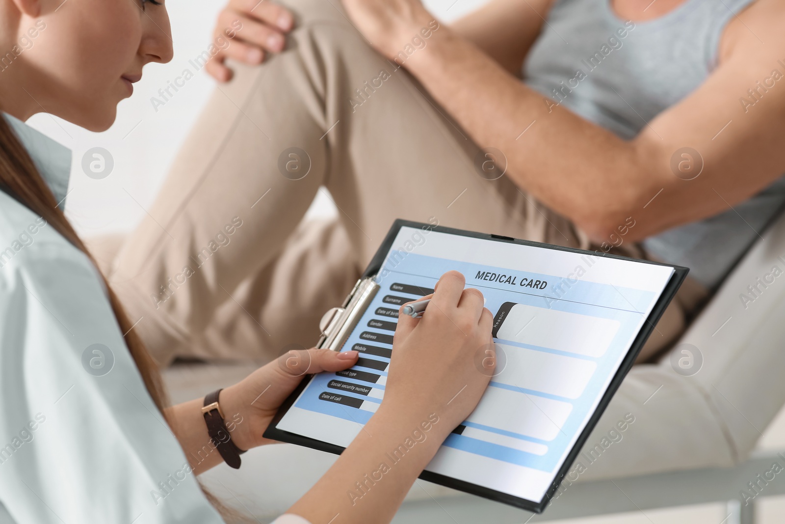 Photo of Doctor filling patient's medical card in clinic, closeup