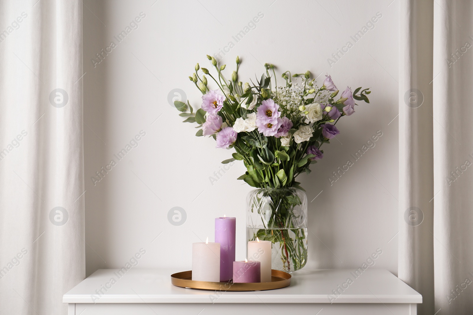 Photo of Bouquet of beautiful Eustoma flowers on table in room