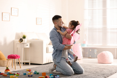 Photo of Father playing with his child at home