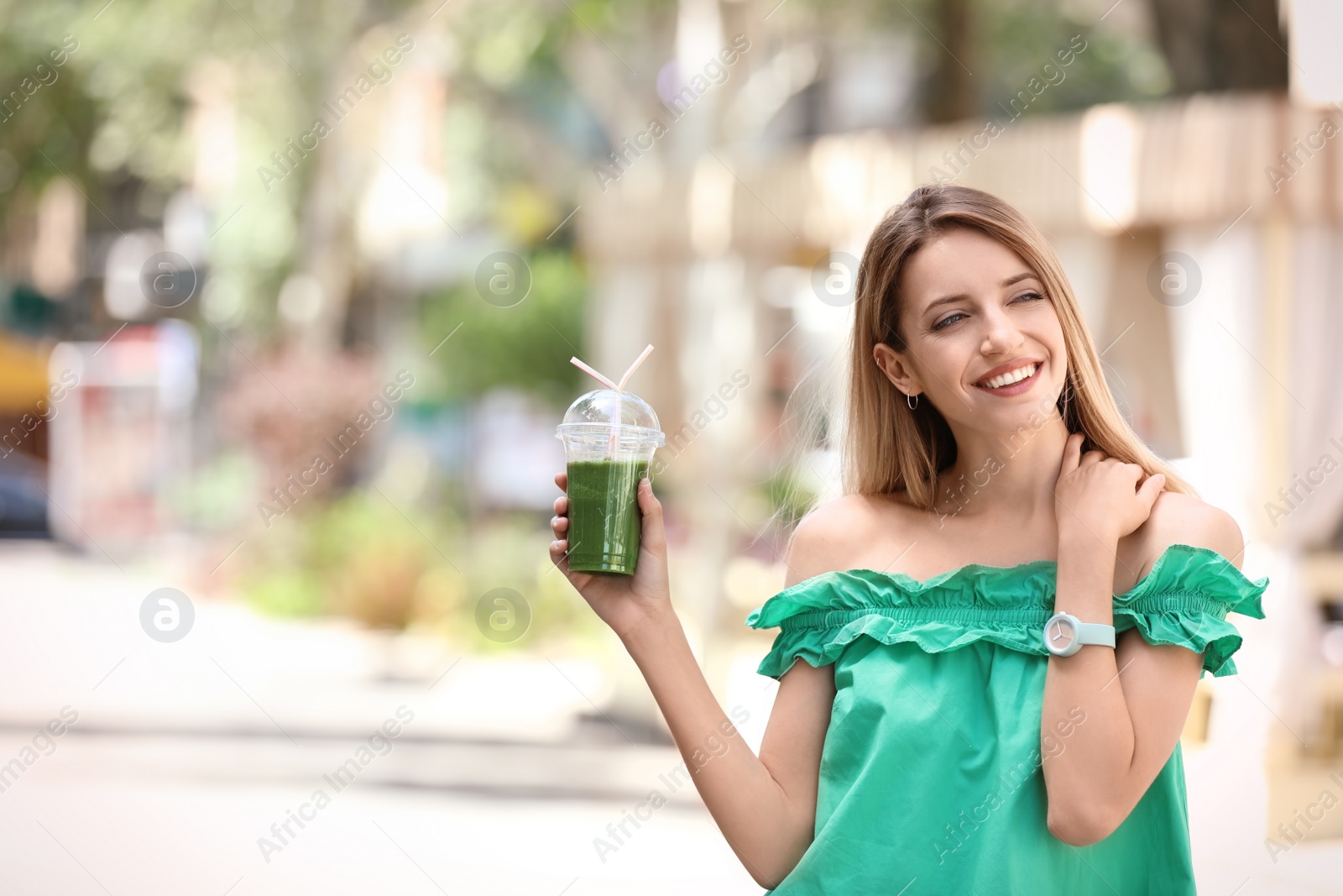 Photo of Young woman with plastic cup of healthy smoothie outdoors