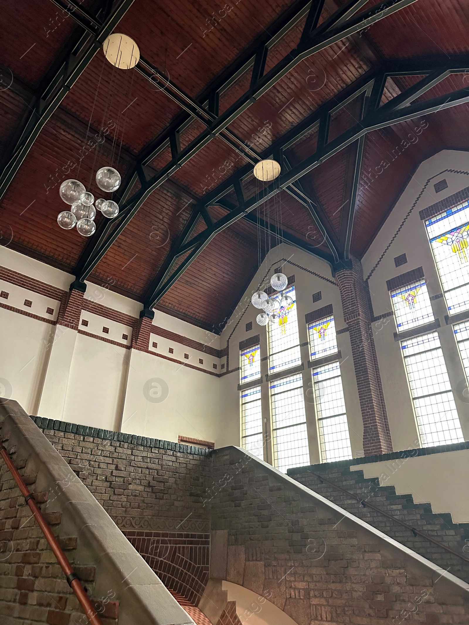 Photo of Lyceum hall with beautiful stained glass windows and modern lamps