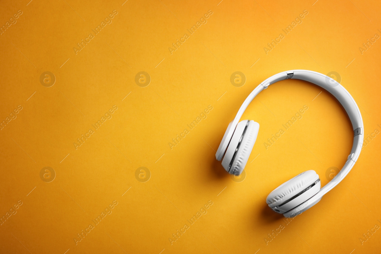 Photo of Wireless headphones on color background, top view. Space for text