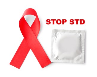 Red awareness ribbon, condom and text Stop STD on white background, top view 