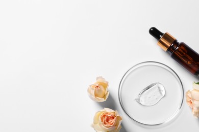 Petri dish with sample of cosmetic serum, bottle and rose flowers on white background, flat lay. Space for text