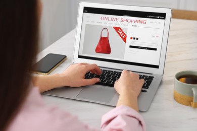 Photo of Woman shopping online during sale on laptop at home, closeup