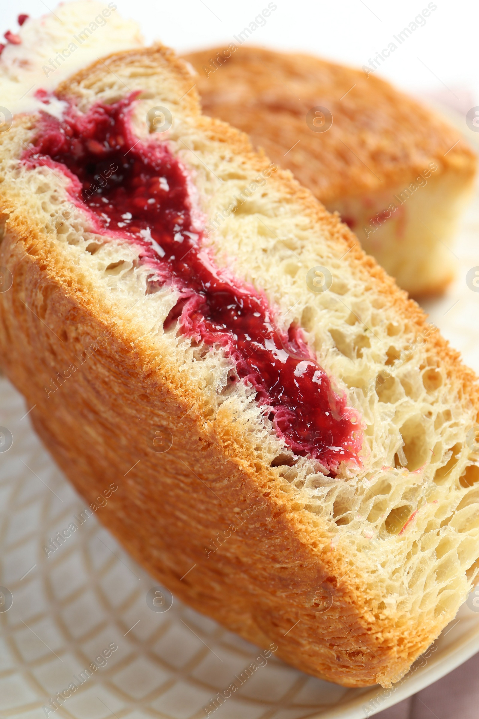 Photo of Round croissant with jam on plate, closeup. Tasty puff pastry