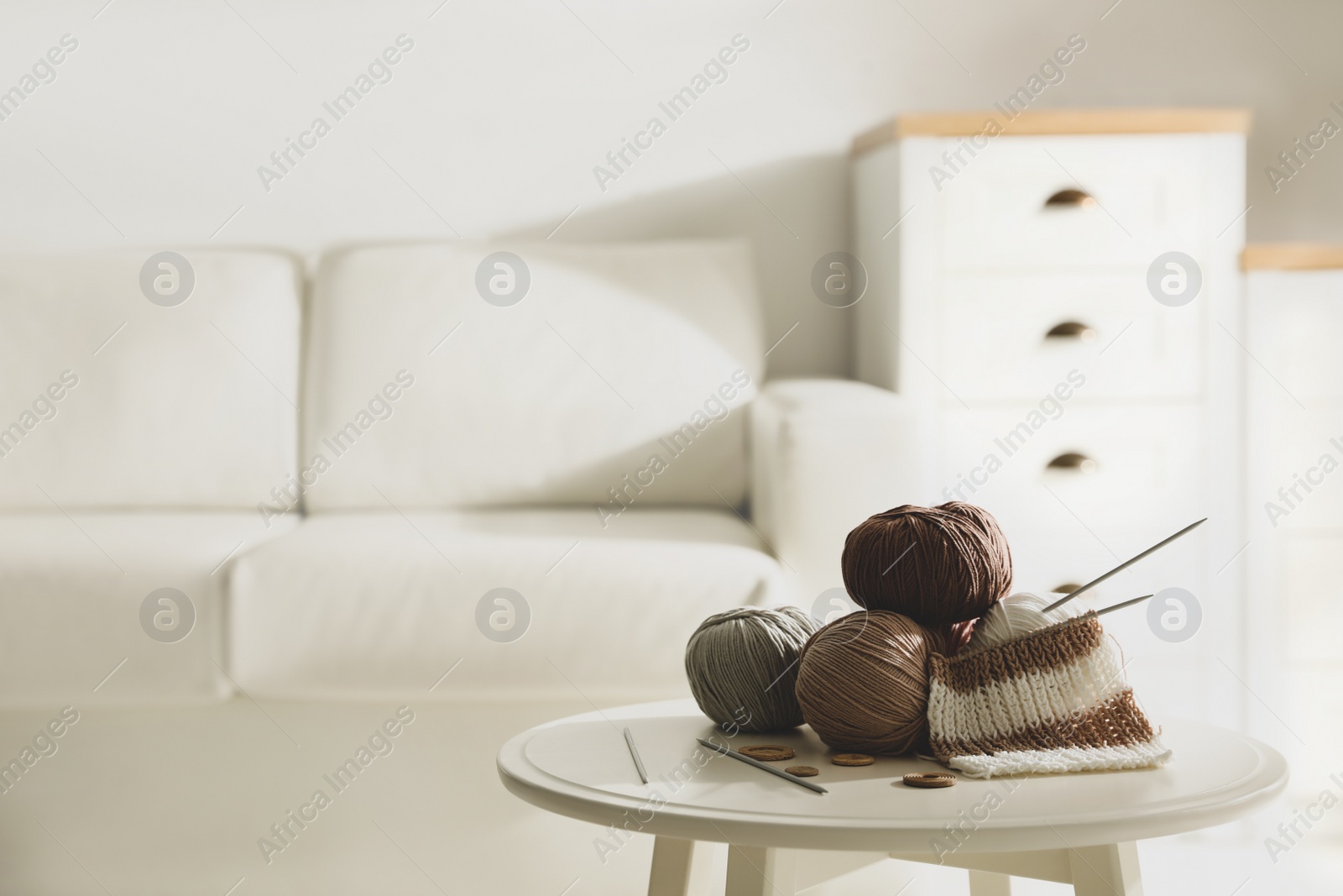 Photo of Yarn balls, buttons and knitting needles on table indoors, space for text. Creative hobby