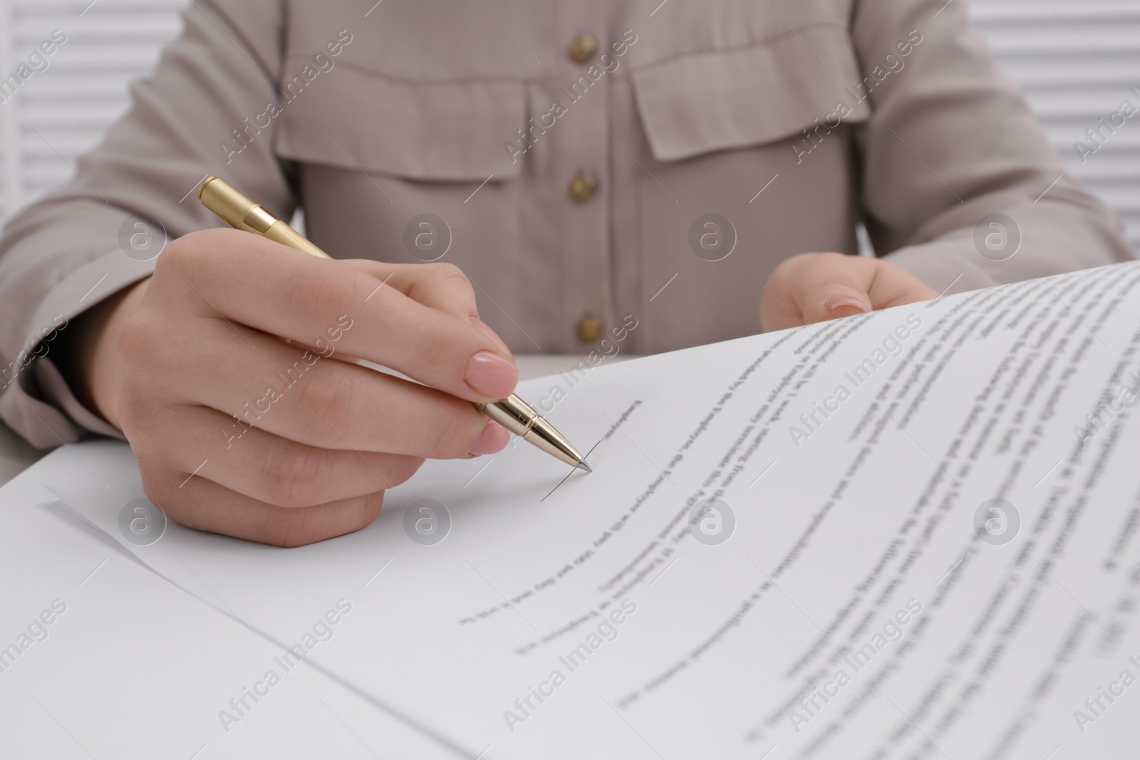 Photo of Woman signing document with pen, closeup view