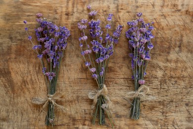 Photo of Bouquets of beautiful lavender flowers on wooden table, flat lay