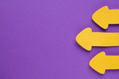 Photo of Paper arrows on purple background, flat lay. Space for text