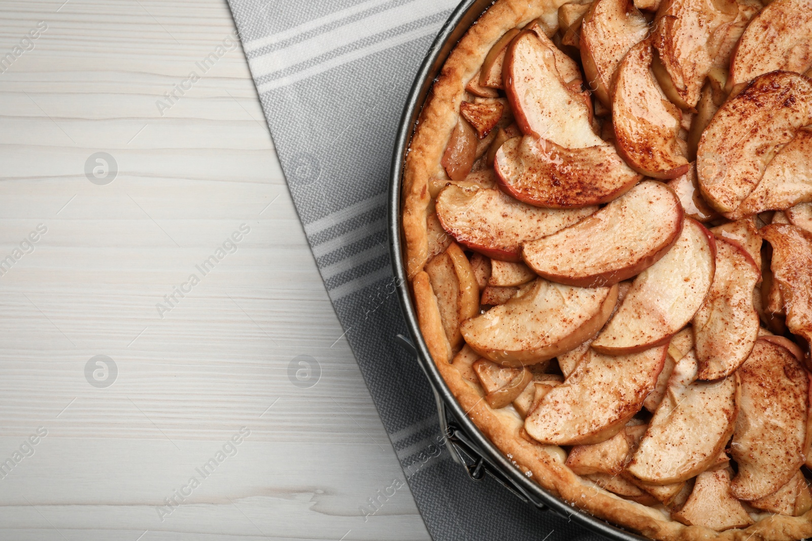 Photo of Delicious apple pie on white wooden table, top view. Space for text