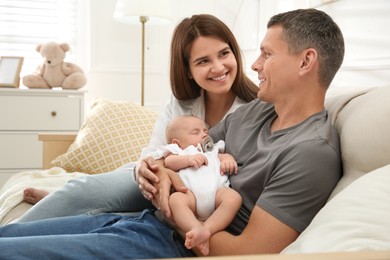 Photo of Happy couple holding their sleeping baby at home