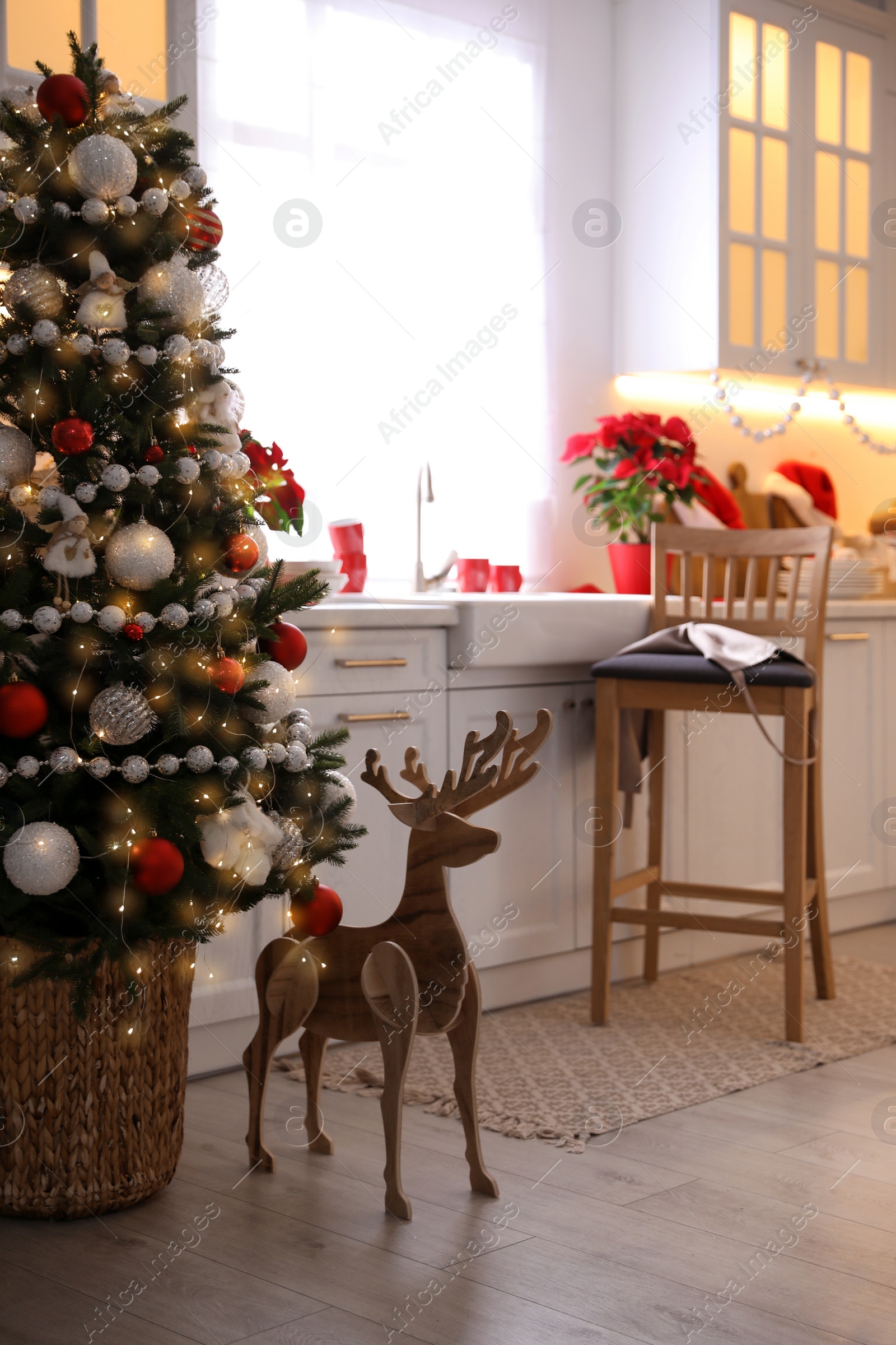 Photo of Beautiful kitchen interior with Christmas tree and festive decor