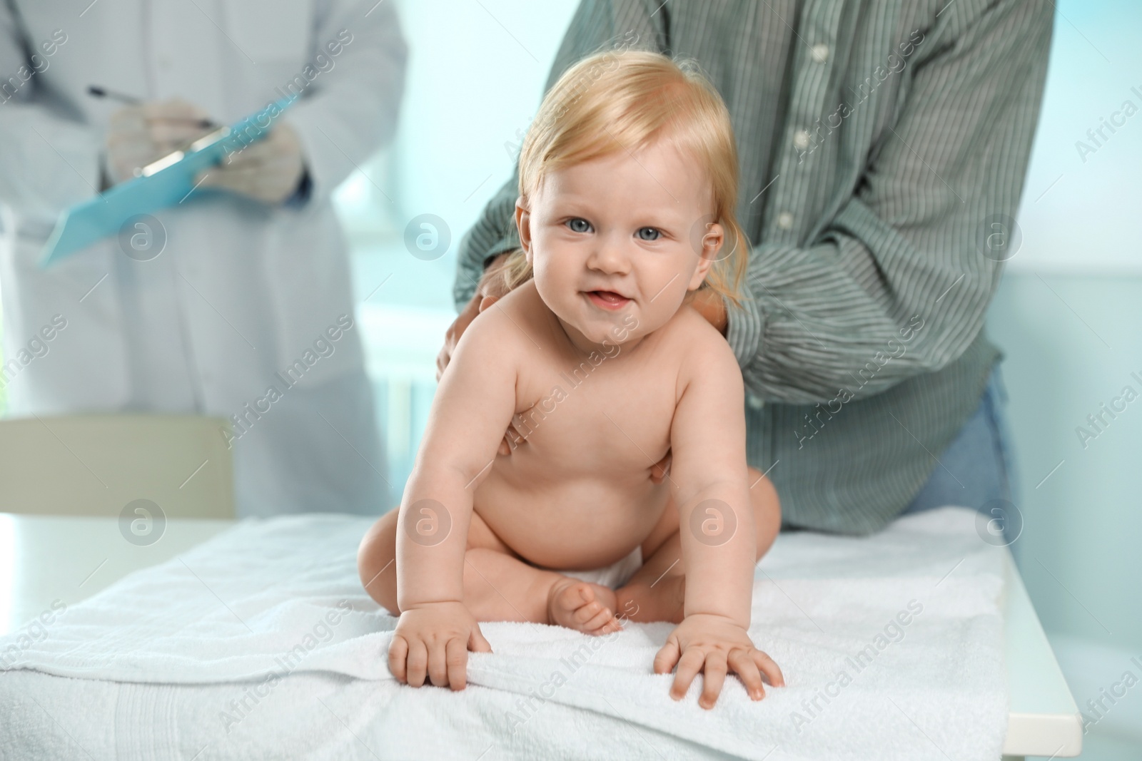 Photo of Mother with her baby visiting pediatrician in hospital. Health growth