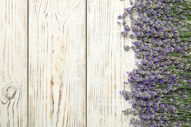 Photo of Beautiful tender lavender flowers on white wooden table, top view. Space for text