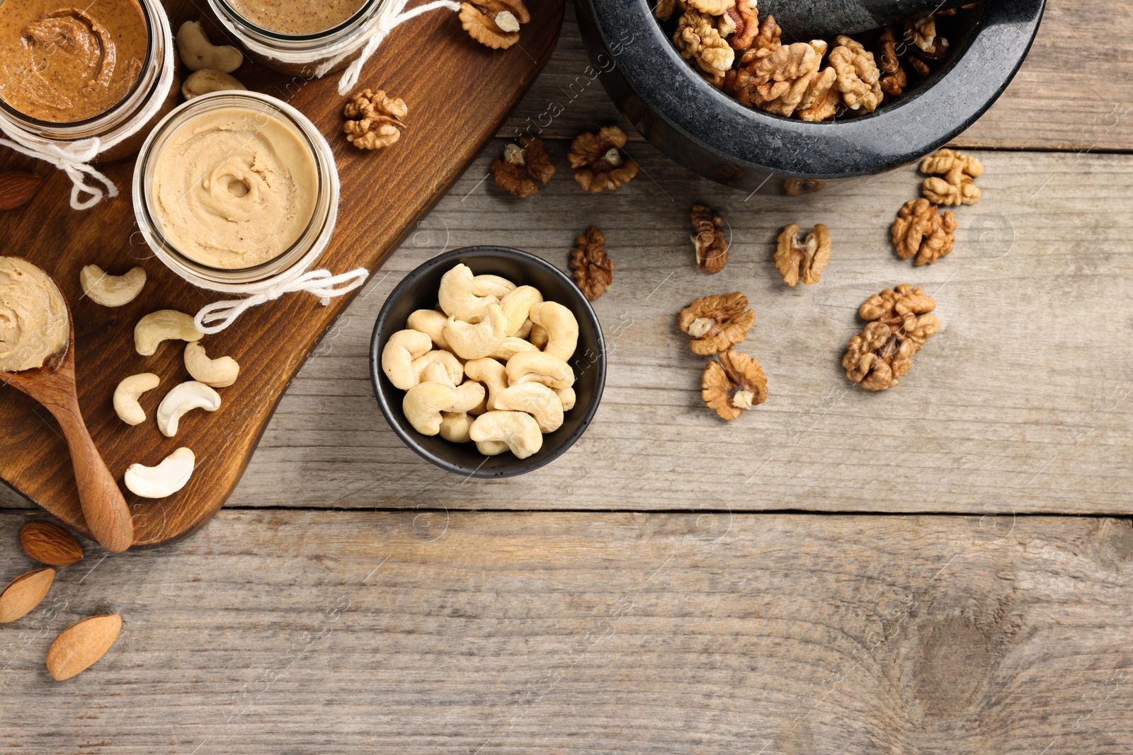 Photo of Making nut butters from different nuts. Fat lay composition with space for text on wooden table