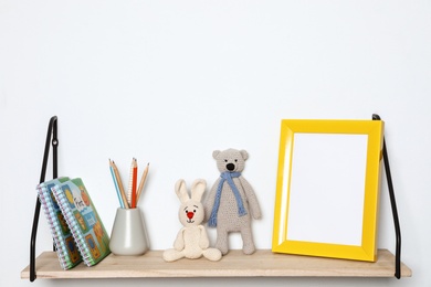 Photo of Composition with soft toys and photo frame on shelf. Child room interior decor